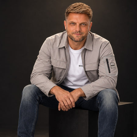BOSS overshirt, tee and jeans, seated in a black studio