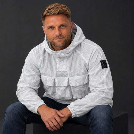 Marshall Artist overhead jacket, seated in a black studio